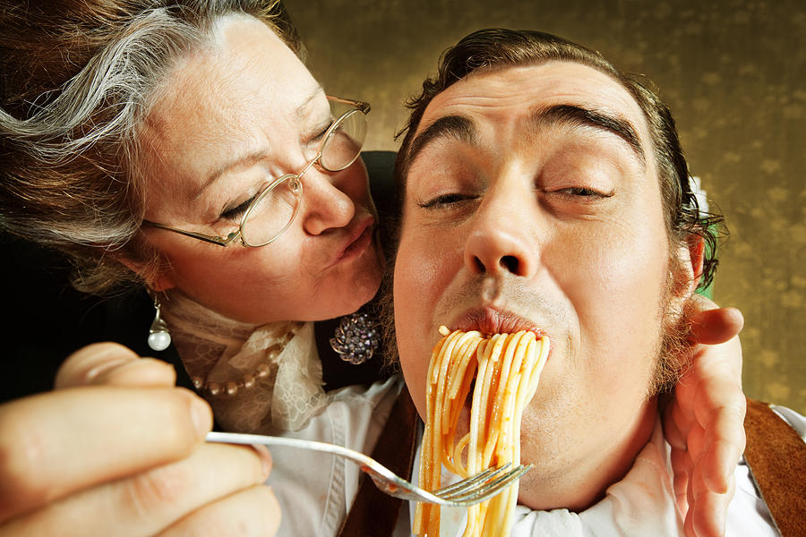 Overzealous Mother Feeding Adult Son Pasta Photograph by Nikada