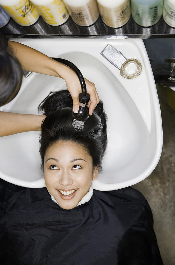 Pacific Islander woman having hair washed at salon Photograph by Andersen Ross Photography Inc