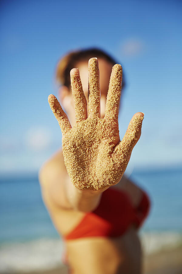 Pacific Islander woman holding out sandy hand Photograph by Colin Anderson Productions pty ltd