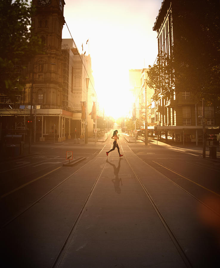 Pacific Islander woman jogging at sunset Photograph by Colin Anderson Productions pty ltd