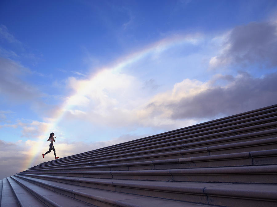 Pacific Islander woman jogging on concrete steps Photograph by Colin Anderson Productions pty ltd