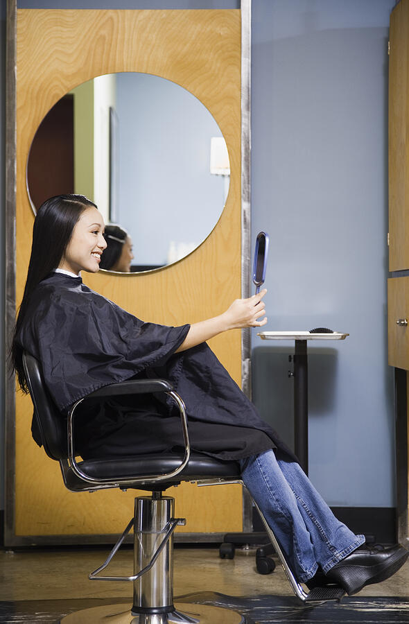 Pacific Islander woman looking at hair in salon Photograph by Andersen Ross Photography Inc