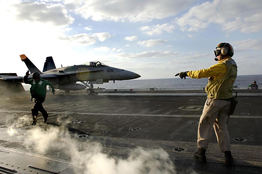 Pacific Ocean (November 13, 2006) - Chief Aviation Boatswains Mate ensures an F/A-18C Hornet is cleared for launch from the flight deck aboard USS Kitty Hawk (CV 63). Photograph by Stocktrek Images