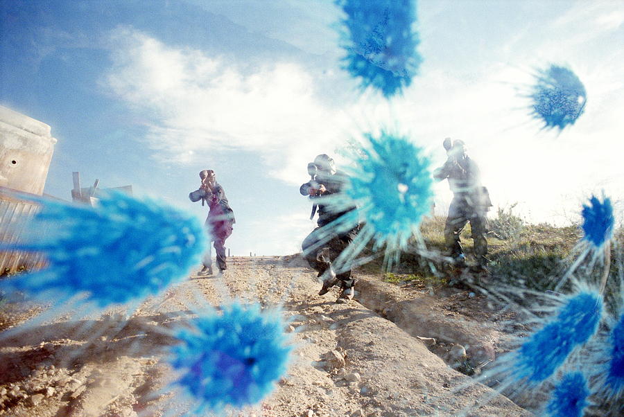 Paint ball battle, players in camouflage shooting paint on glass Photograph by Sean Murphy