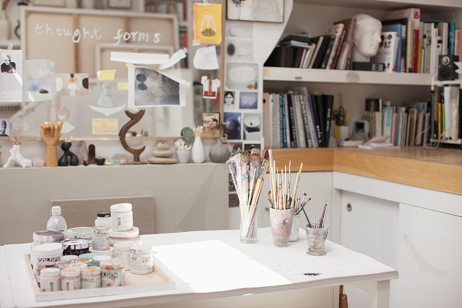 Paintbrushes in jars in art studio Photograph by Tom Merton