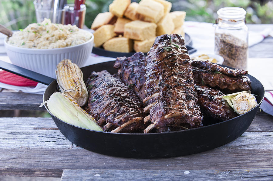 Pan of barbecue ribs on wooden table Photograph by Manny Rodriguez