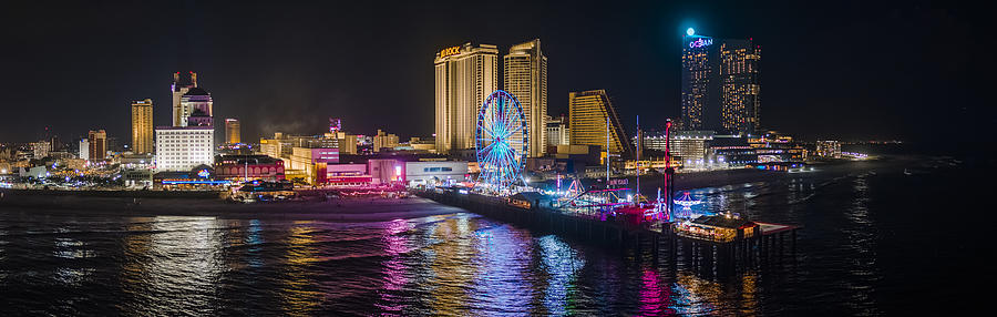 Panoramic aerial view of the Broadwalk on the waterfront in Atlantic City Downtown, the famous gambling center of the East Coast USA, with multiple casinos and amusing park with a Ferris Wheel on a pier. Photograph by Alex Potemkin