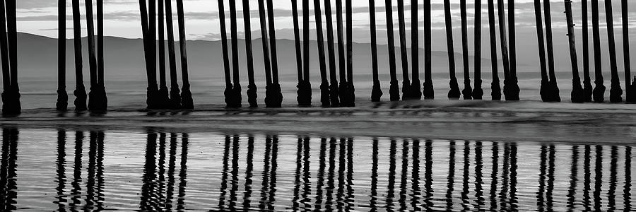Black And White Photograph - Panoramic Pismo Beach Pier Pilings - Black and White by Gregory Ballos