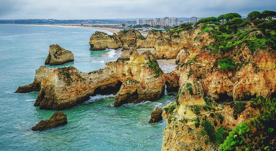 Panoramic view of the Algarves rocky coastline, where cliffs me Photograph by Hanna Tor