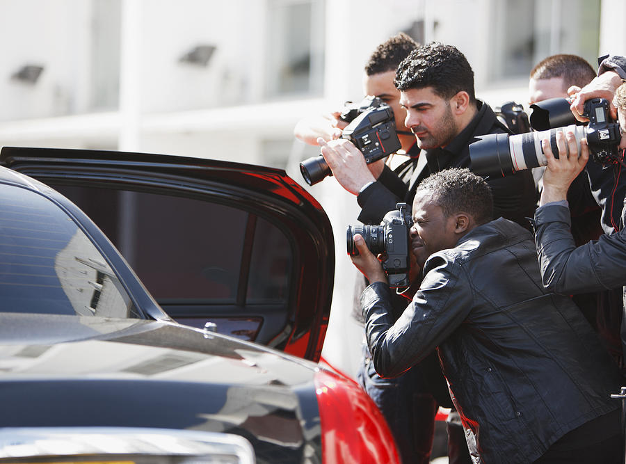 Paparazzi taking pictures of celebrity in car Photograph by Paul Bradbury