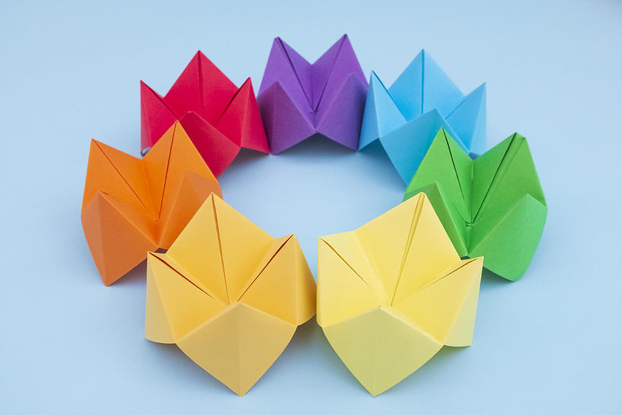 Paper Fortune Tellers arranged by colour on a blue background Photograph by Catherine MacBride