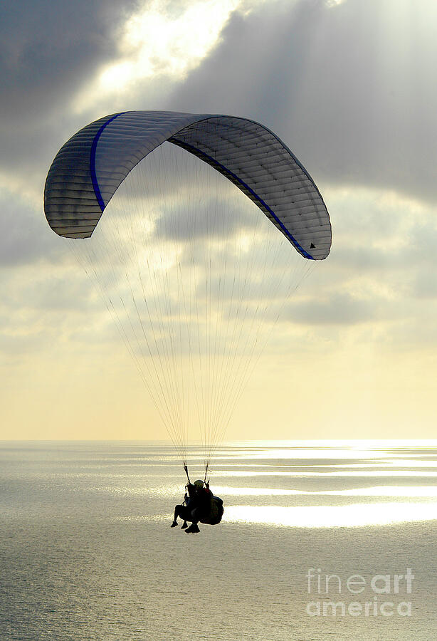 Paragliders riding tandem into the sunset Photograph by Gunther Allen