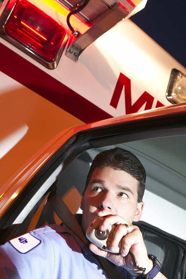 Paramedic using radio in ambulance Photograph by Thinkstock Images