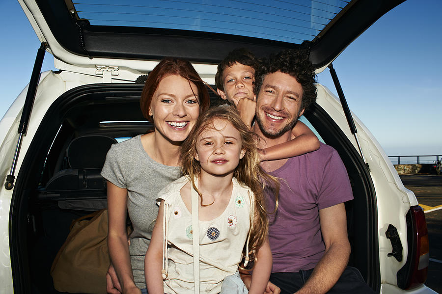 Parents and two children in family car, portrait Photograph by Uwe Krejci