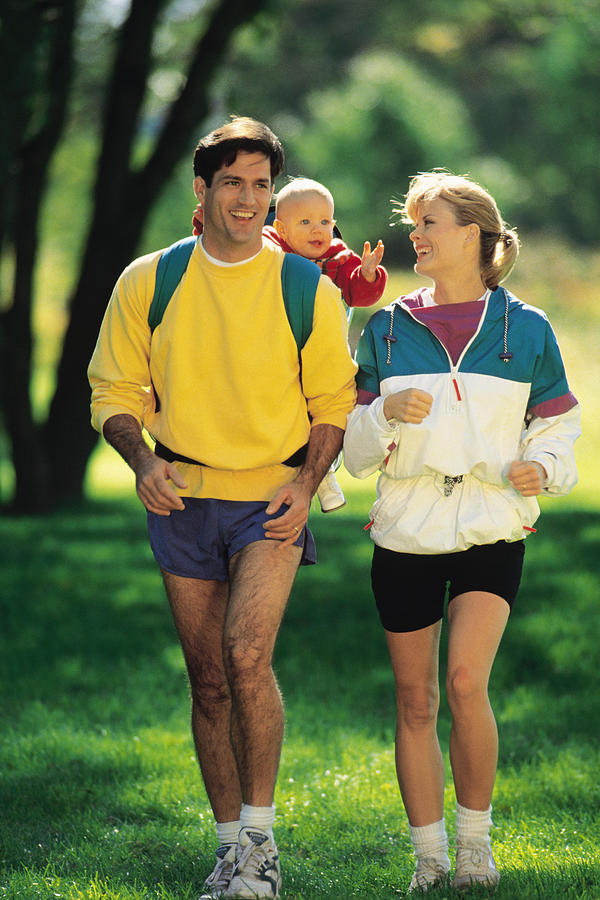 Parents jogging with baby Photograph by Comstock