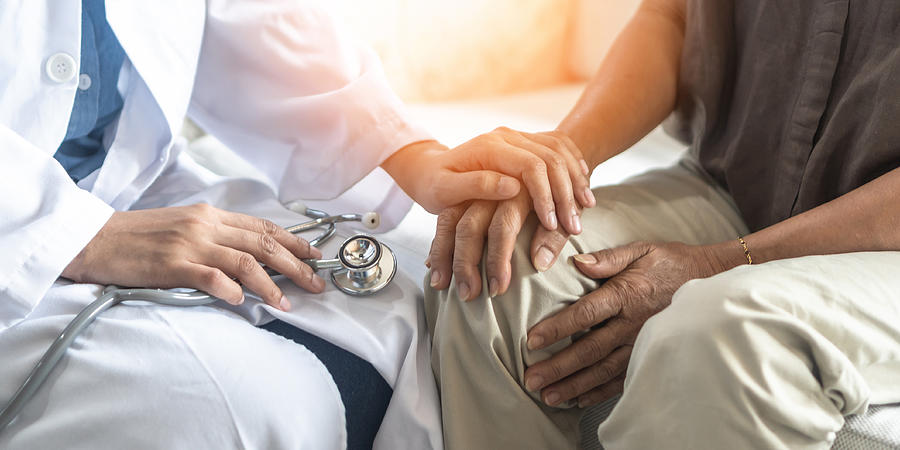 Parkinsons disease patient, Arthritis hand and knee pain or mental health care concept with geriatric doctor consulting examining elderly senior aged adult in medical exam clinic or hospital Photograph by Chinnapong