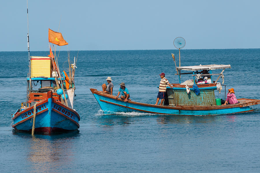 People and boats moving at the fishery harbor Photograph by Jethuynh
