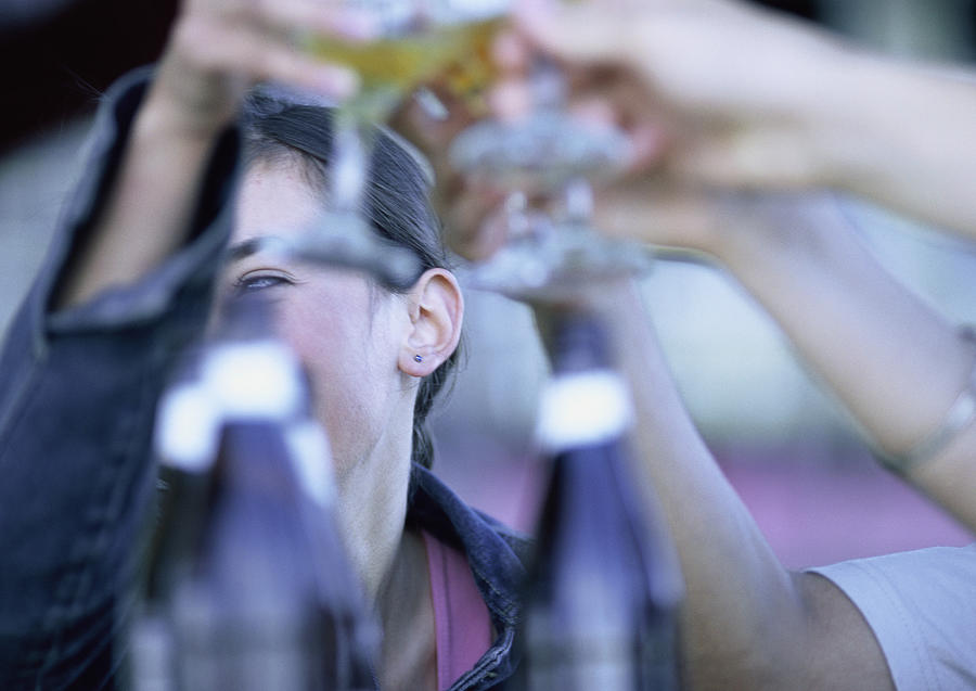 People clanking glasses together, close-up. Photograph by Gerard Launet