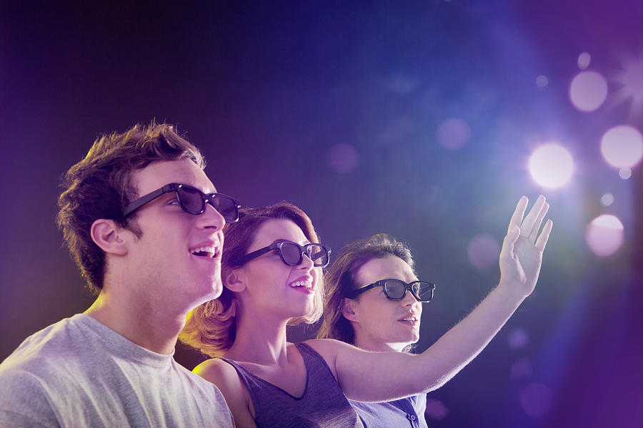 People in 3D glasses looking towards light Photograph by Image Source