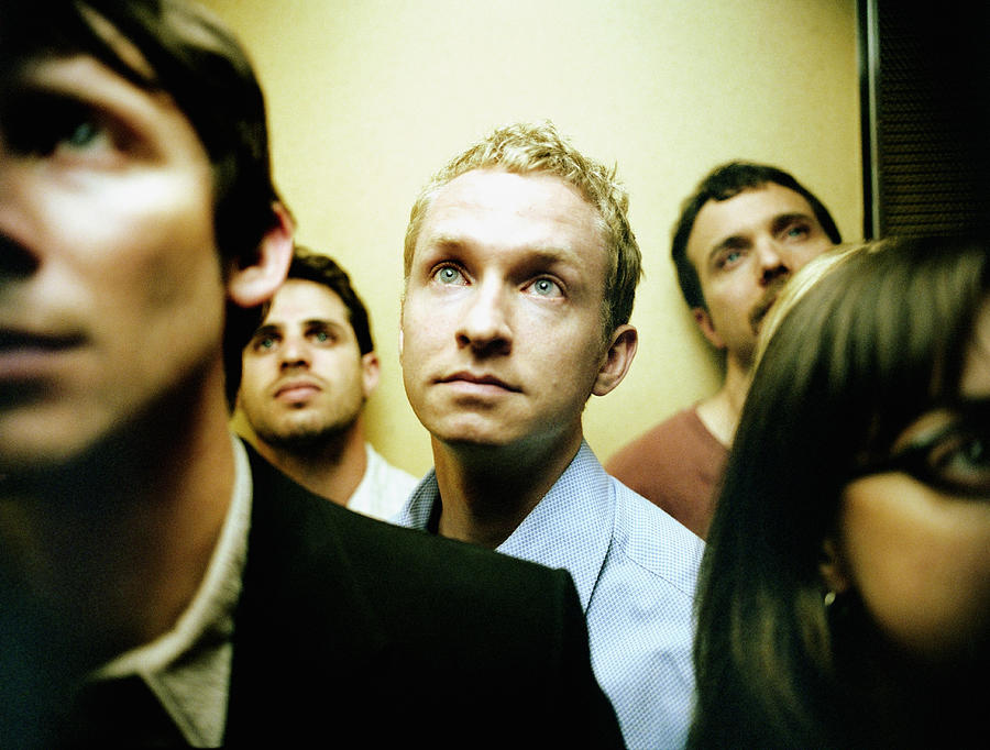 People in elevator, close up (focus on blond man) Photograph by David Sacks