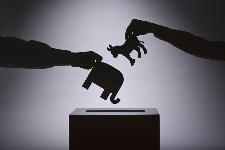 People putting political symbols in box Photograph by Comstock Images