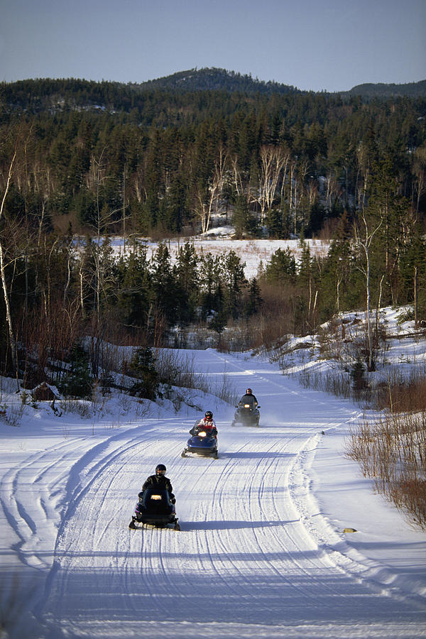 People riding snowmobiles Photograph by Comstock Images