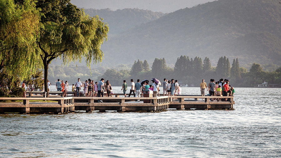 People strolling at the edge of the West Lake Photograph by Benoit Bruchez