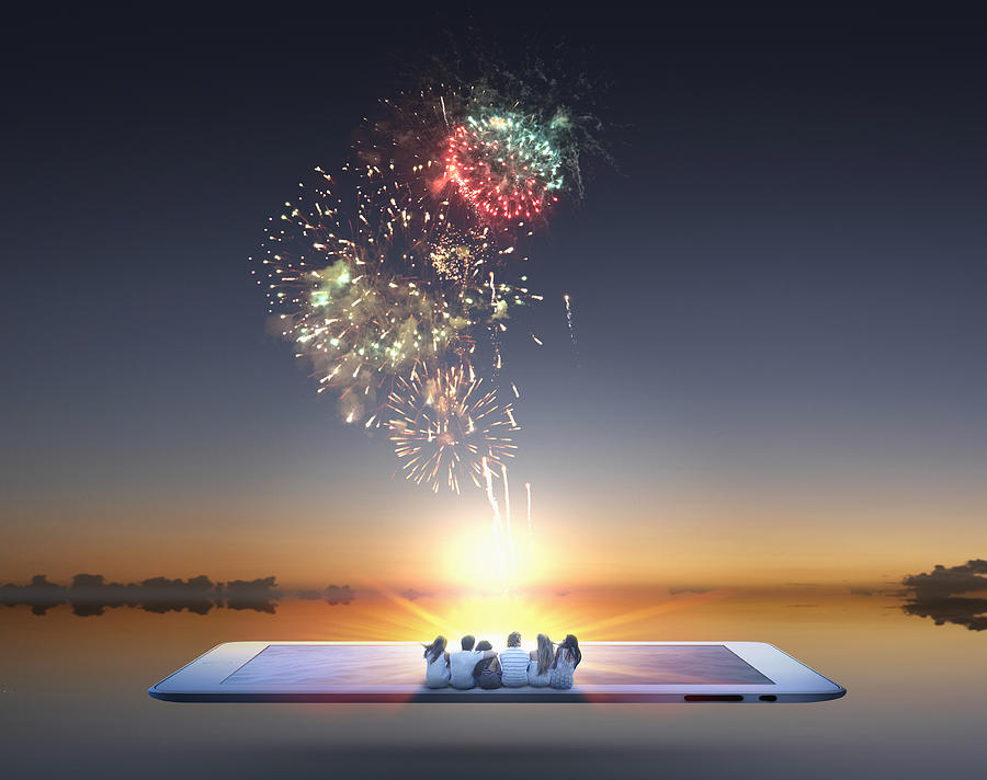 People watching fireworks erupt from digital tablet Photograph by Colin Anderson Productions pty ltd