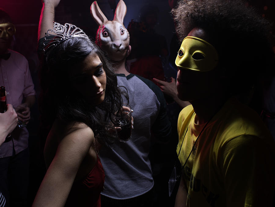People wearing costumes, dancing in night club Photograph by Michael Blann