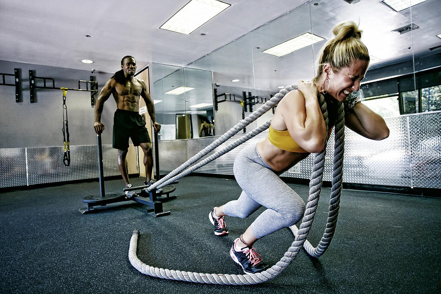 People working out with ropes in gym Photograph by Peathegee Inc