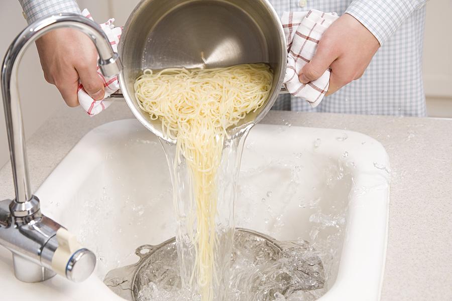 Person draining spaghetti Photograph by Image Source