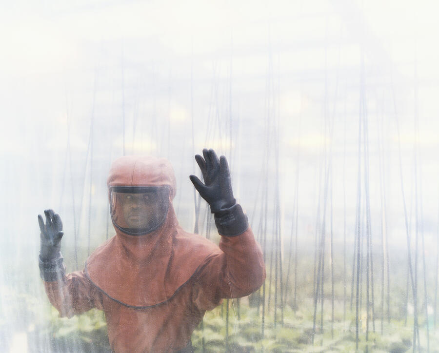 Person Dressed in Protective Clothing Standing in a Greenhouse Photograph by Noel Hendrickson