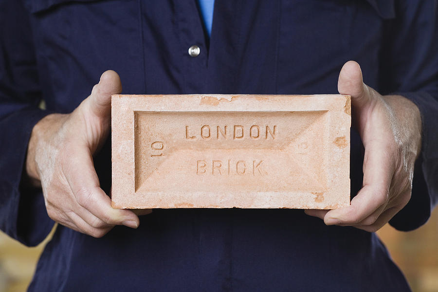 Person holding a brick Photograph by Image Source