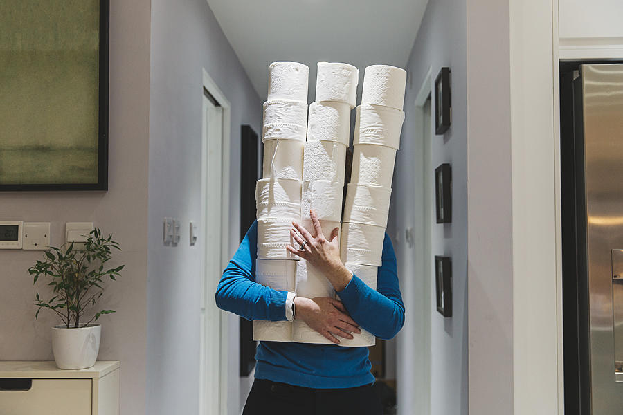 Person holding large piles of toilet rolls Photograph by Justin Paget