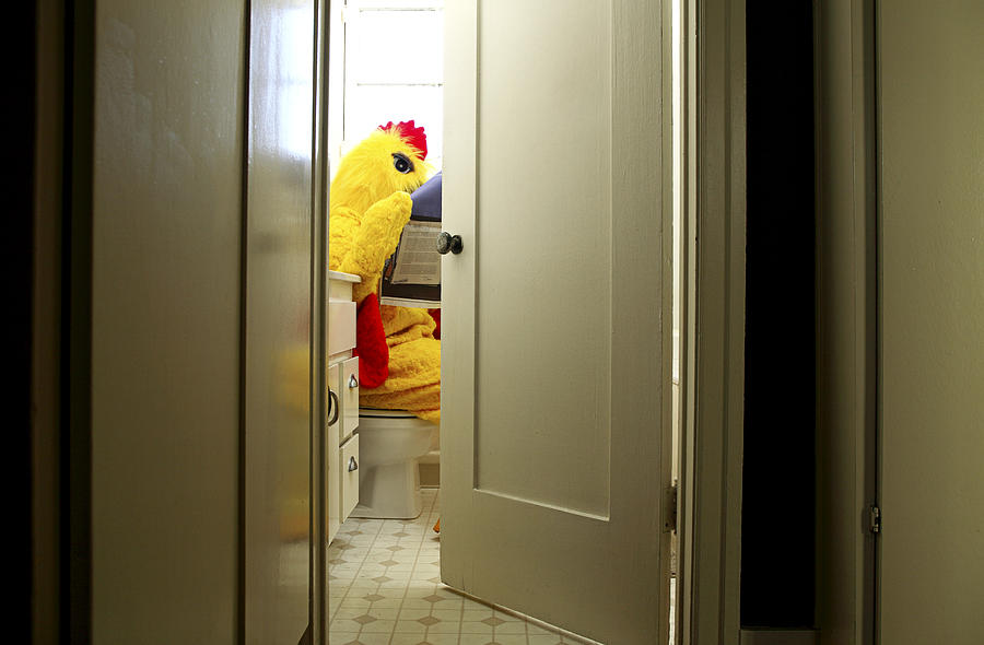 Person in chicken costume sitting on toilet reading newspaper Photograph by Eric Chuang
