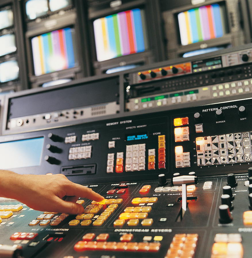 Person Pressing Buttons on a TV Studio Control Panel Photograph by Digital Vision.