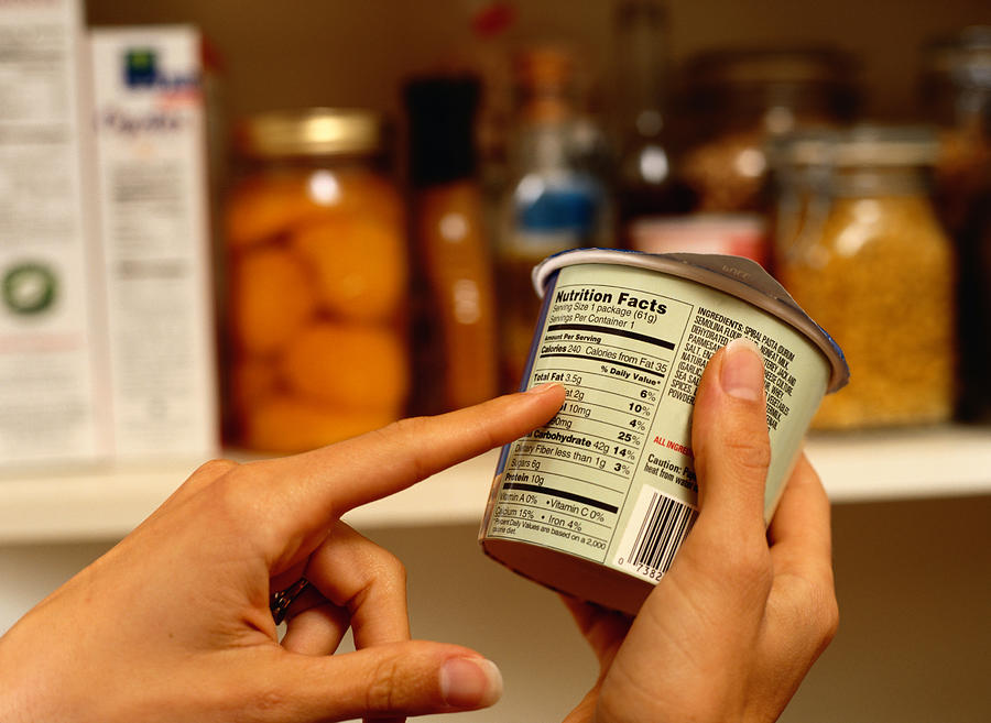 Person Reading Nutrition Label on Packaged Food Photograph by Ryan McVay