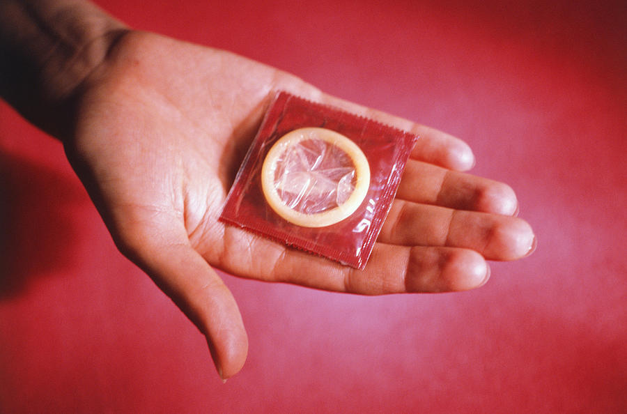 Person showing condom, Close-up of hand Photograph by Photodisc