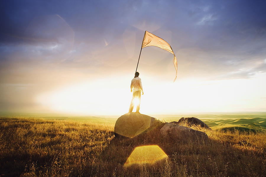 Person standing in field with flag Photograph by Brand X Pictures