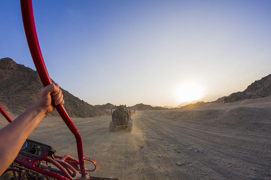 Personal perspective view of mans arm driving beach buggy in desert, Hurghada, Al Bahr al Ahmar, Egypt Photograph by Chuvashov Maxim