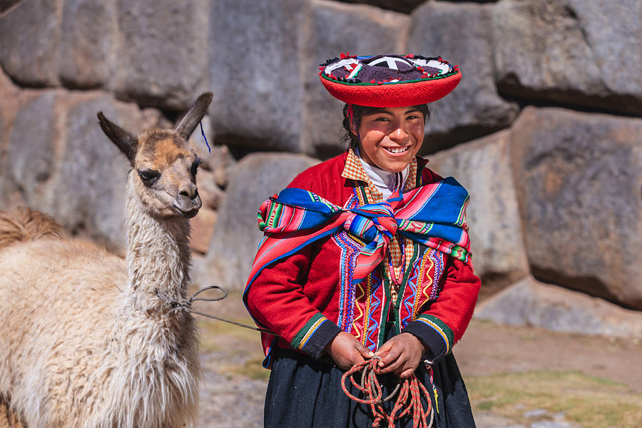 Peruvian girl wearing national clothing walking with llama near Cuzco Photograph by Bartosz Hadyniak