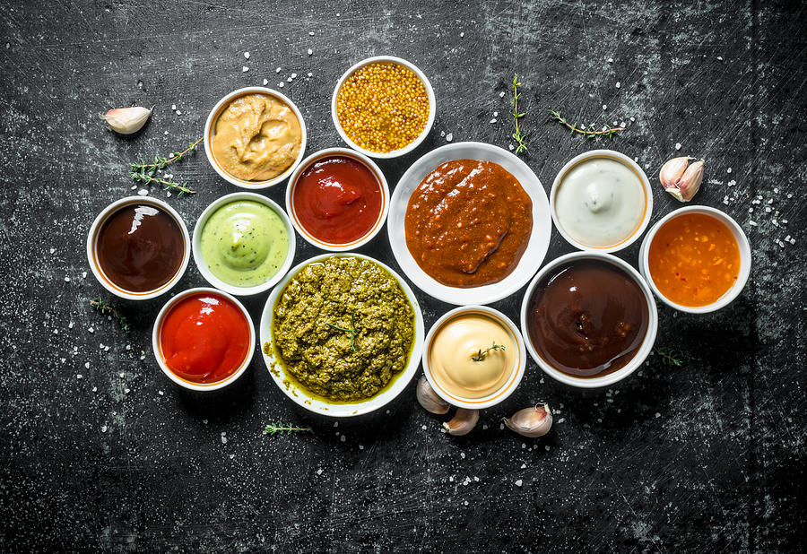Pesto sauce, guacomole, ketchup, mustard, barbecue sauce in bowls. Photograph by Olesia Shadrina