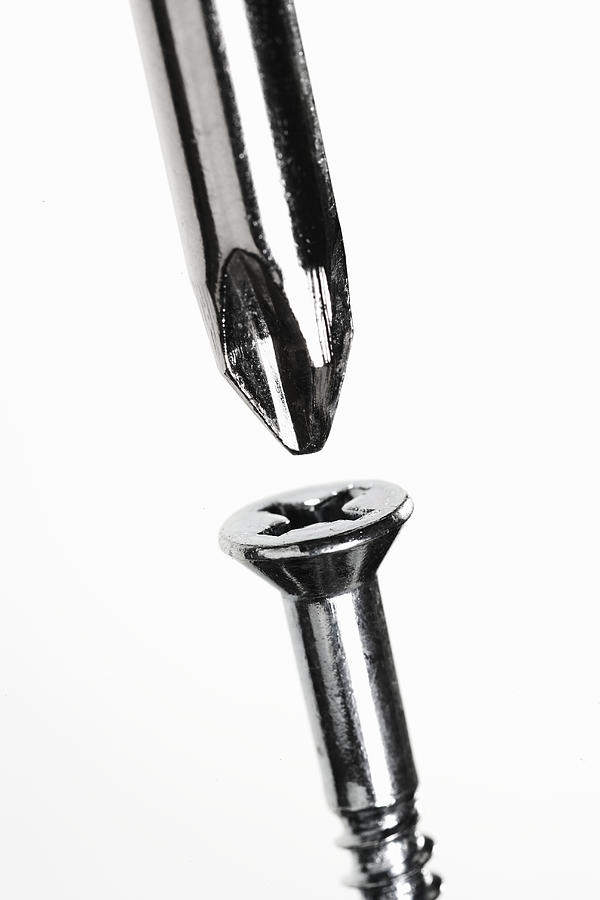 Phillips-head screw and screwdriver, close-up Photograph by Thomas Northcut