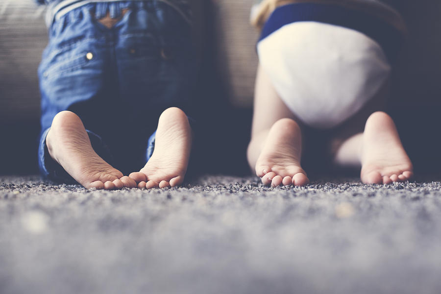 Photograph of the feet of two twin brothers playing together Photograph by Estersinhache fotografía