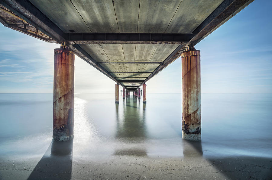 Pier or jetty seen from below, beach and sea in Marina di Pietra Photograph by Stefano Orazzini