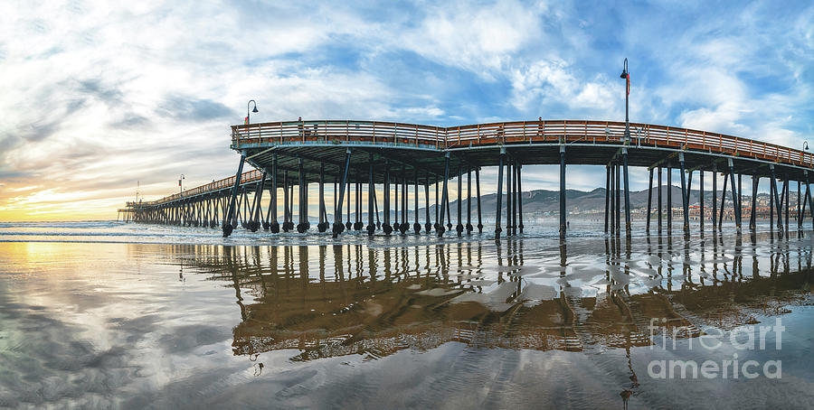 Pier that stretches toward the setting sun, panorama. Photograph by Hanna Tor