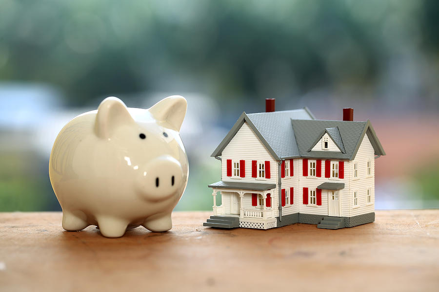 Piggy bank and miniature house,Close up Photograph by Dev Images