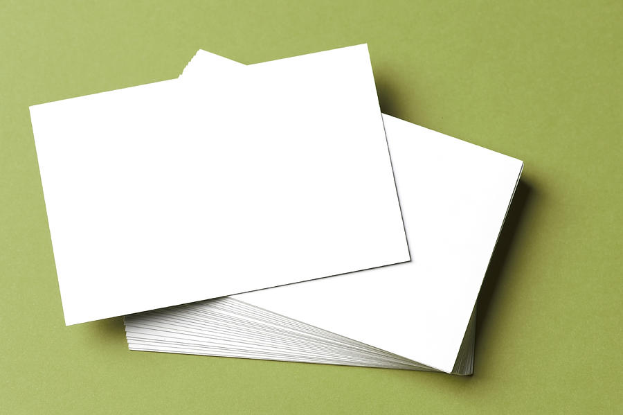 Pile of blank white cards on a green surface/background Photograph by Rustemgurler