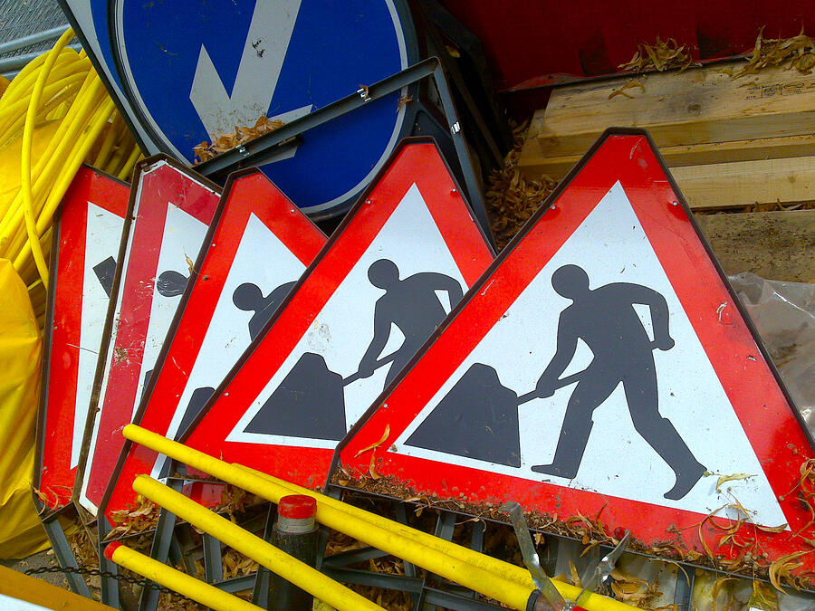 Pile of Men at work signs Photograph by Ian Dennis
