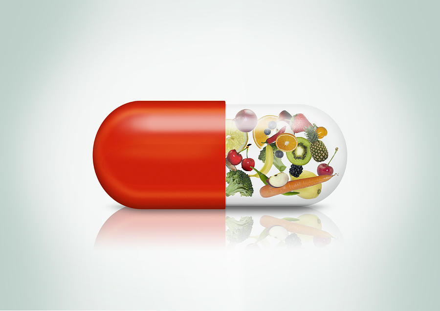 Pill capsule with a variation of fruits visible Photograph by Luxx Images